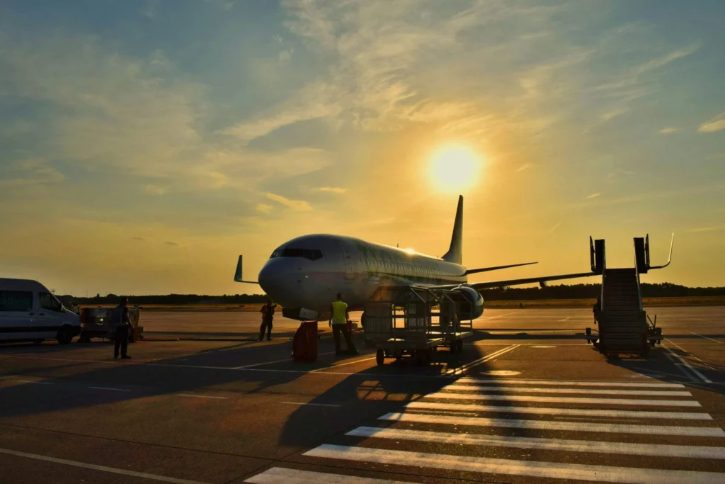 Avion sur le tarmac au coucher du soleil illustrant l'accueil du défunt à son arrivée dans le pays d'inhumation