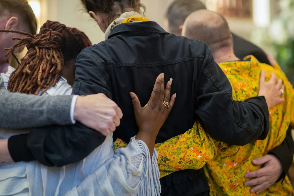 Groupe de personnes qui s'étreignent chaleureusement.